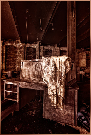 An old, worn wooden desk draped with a faded lace cloth, hinting at forgotten stories.