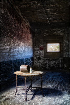 Interior view of a historic industrial space with a wooden table and window