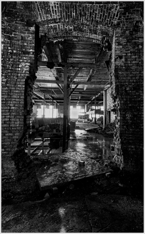 A broken wall reveals a dimly lit, abandoned interior with brick and wood textures.