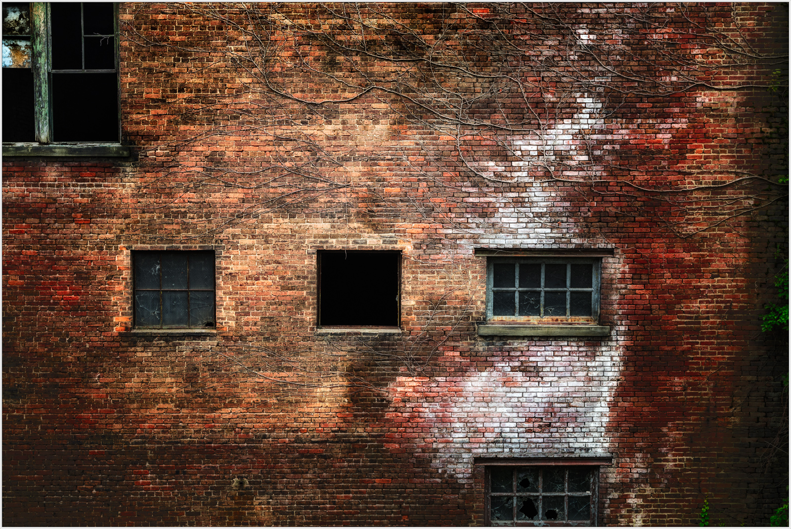 A weathered brick facade reveals time's silent touch and forgotten stories.