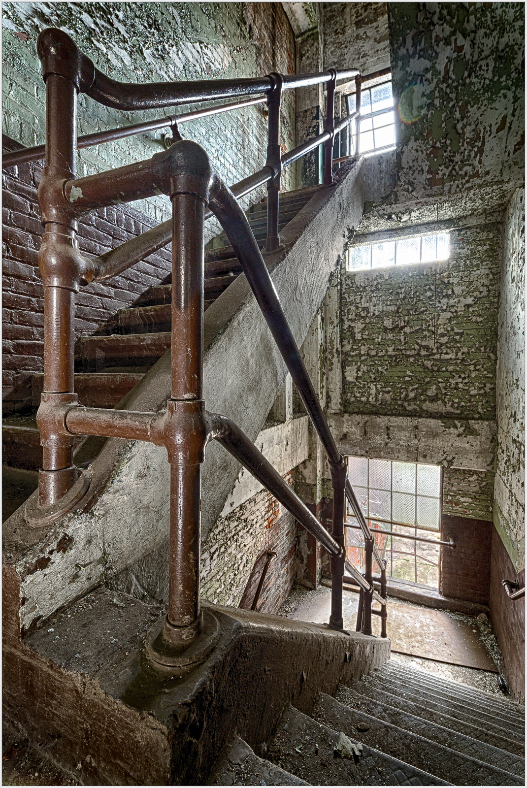 A rusty railing guides you down a worn staircase, echoing stories of the past.