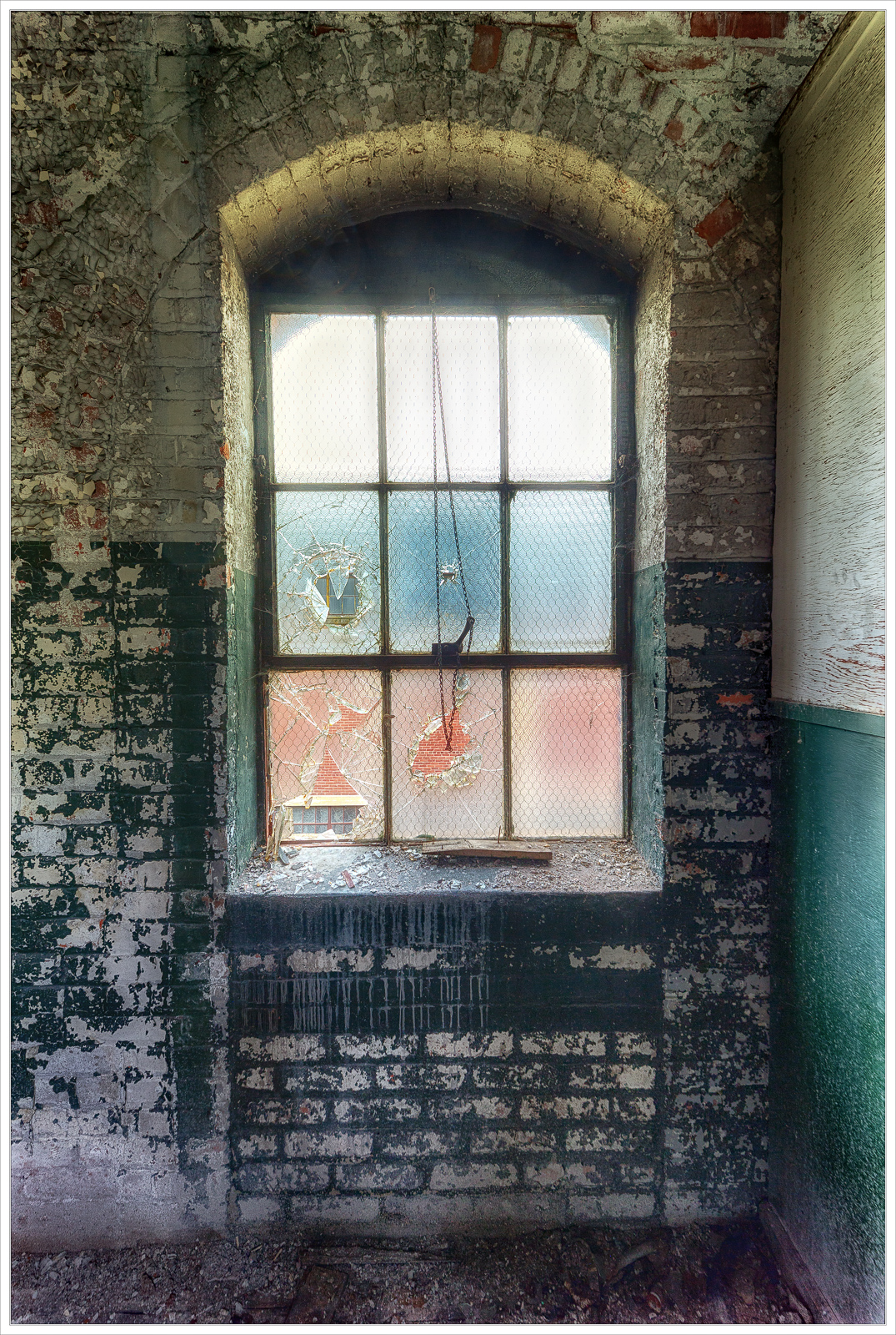 A somber window, shrouded in neglect and decay, hints at the past.