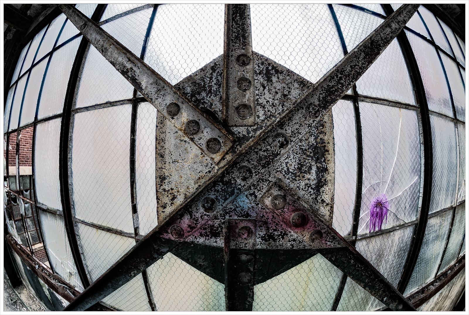 Abandoned building window with rusted metal and peeling glass