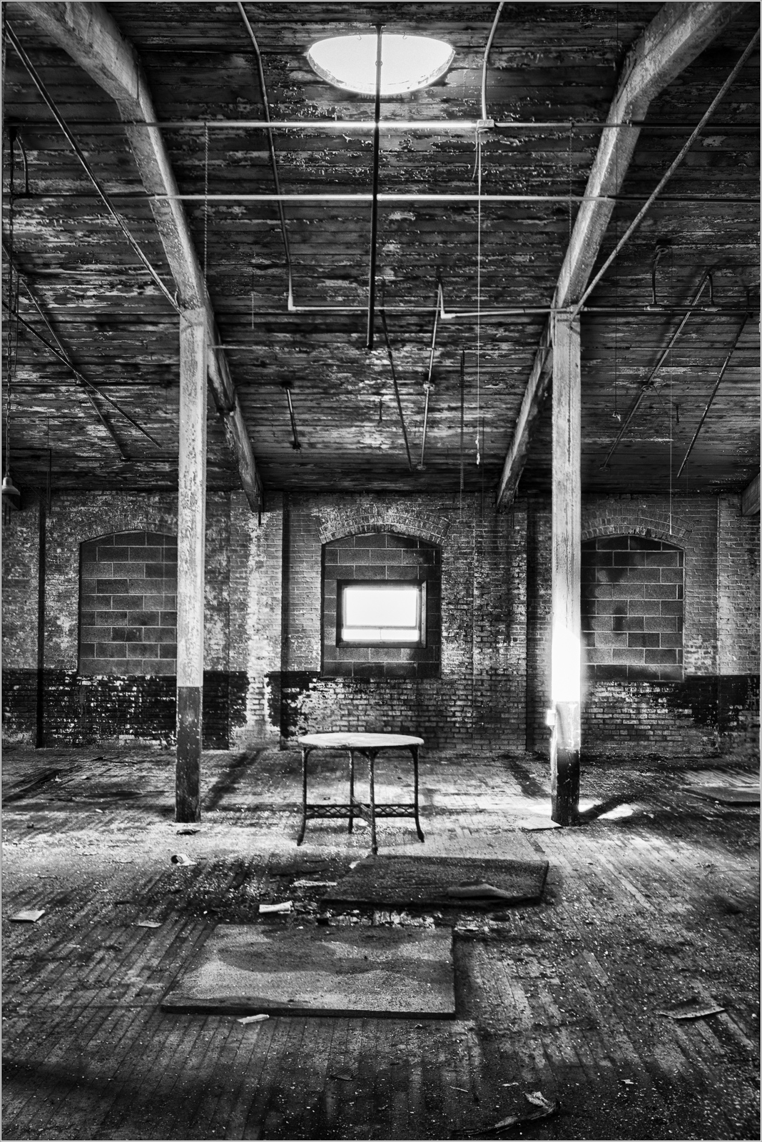 Interior of an abandoned Scranton lace factory with exposed beams and empty space