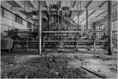 A haunting industrial relic with rusted machinery and shadows lurking.