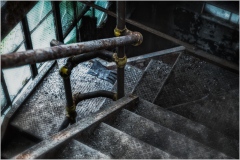 Worn metal stairs lead down, encased in shadows and whispers of forgotten tales.