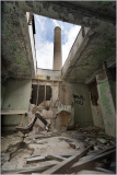 A crumbling interior with a chimney peeking through the ceiling, graffiti on the walls.