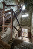 A rusty railing guides you down a worn staircase, echoing stories of the past.