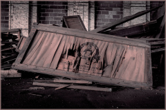 An abandoned frame cradling distorted reflections amidst scattered debris.