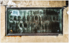 Weathered sign of the Scranton Lace Company, faded but bold, tells stories of resilience.
