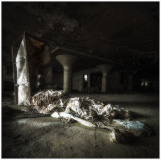 A weathered room draped in tattered fabric, shadows loom heavy.