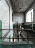 A forgotten corridor with peeling paint and a railing, exuding industrial nostalgia.