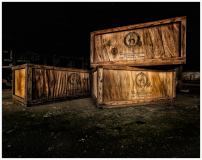 Weathered wooden crates rest in darkness, echoes of industry linger.