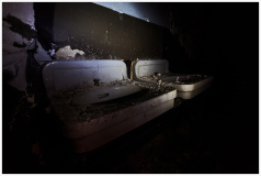 Abandoned sinks shrouded in dust, a ghastly reminder of forgotten lives.