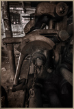 A weathered industrial machine, rusted and forgotten, whispers secrets of a bygone era.