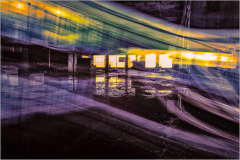 A vibrant display of light and color in an abandoned industrial space.