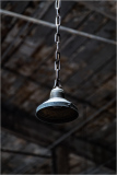 Hanging industrial light fixture with chain support in a rustic interior
