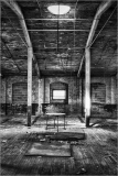 Interior of an abandoned Scranton lace factory with exposed beams and empty space