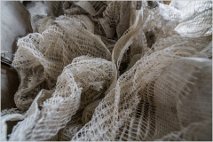 Close-up of delicate, tangled lace fabric in soft, muted tones.