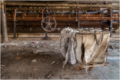 An old industrial area with a weathered crate and machinery in the background.