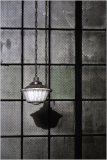 Hanging light shines bright, casting shadows on the wall, vintage glow in dark.