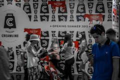 A bustling scene of people in motion against a backdrop of red and black cow graphics.