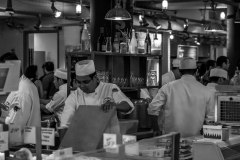 Chefs in a bustling kitchen, focused on their craft amidst a sea of activity.