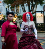Two performers strut in glam costumes with dramatic makeup, ready for a show.