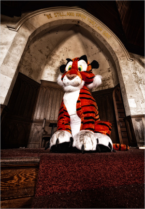 A large, faded tiger mascot sits alone in a decaying, empty space.
