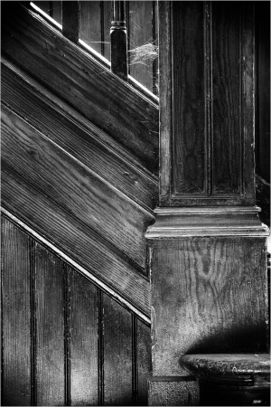 Close-up of a wooden staircase, its grain hinting at years of use and neglect.