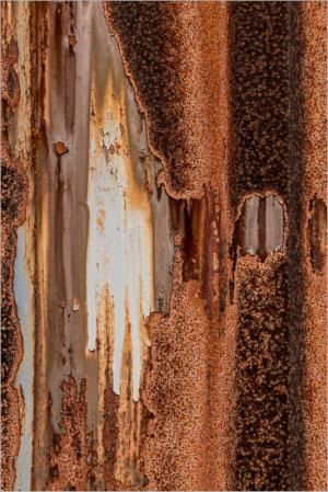 Rusty metal surface with streaks of orange and brown, resembling a weathered canvas.