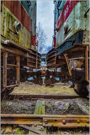Two old trolleys facing each other in a graveyard of rust and nostalgia.
