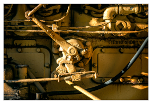 Close-up of rusty machinery with levers and pipes in a trolley graveyard.
