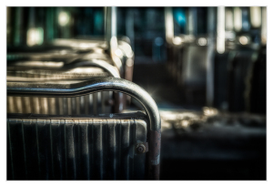 Abandoned trolley seats rusting in a forgotten graveyard of public transport.