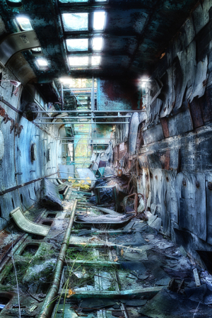 Abandoned trolley graveyard with rusted metal and overgrown tracks.