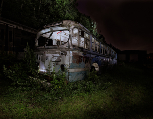 An abandoned, decaying trolley overrun by nature, shrouded in darkness and mystery.