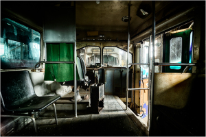 Interior of an abandoned trolley, shadows loom in the eldritch gloom.
