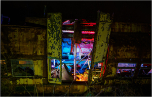 A rusted trolley with peeling paint, illuminated by eerie lights.