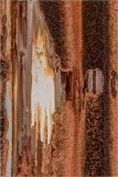 Rusty metal surface with streaks of orange and brown, resembling a weathered canvas.