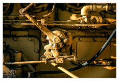 Close-up of rusty machinery with levers and pipes in a trolley graveyard.