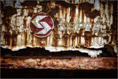 Faded signage clings to rusted metal, echoing forgotten journeys.