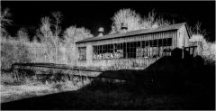 A forsaken structure looms amidst the shadows of a desolate landscape.