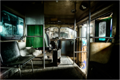 Interior of an abandoned trolley, shadows loom in the eldritch gloom.