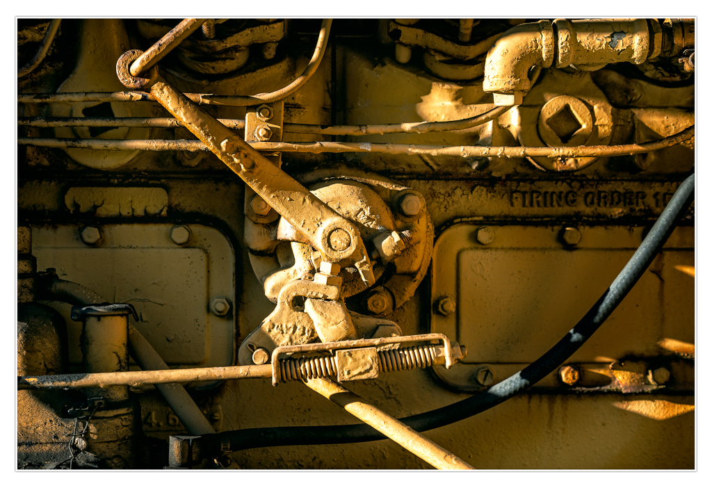 Close-up of rusty machinery with levers and pipes in a trolley graveyard.