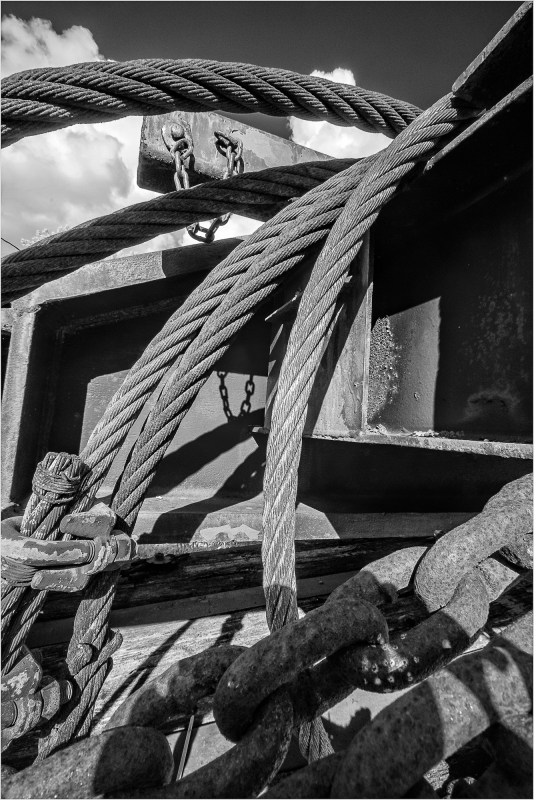 A tangle of ropes and chains, shadows intertwine in a dreamlike embrace.