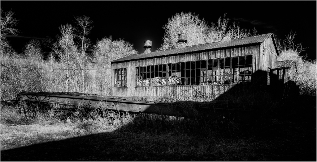 A forsaken structure looms amidst the shadows of a desolate landscape.