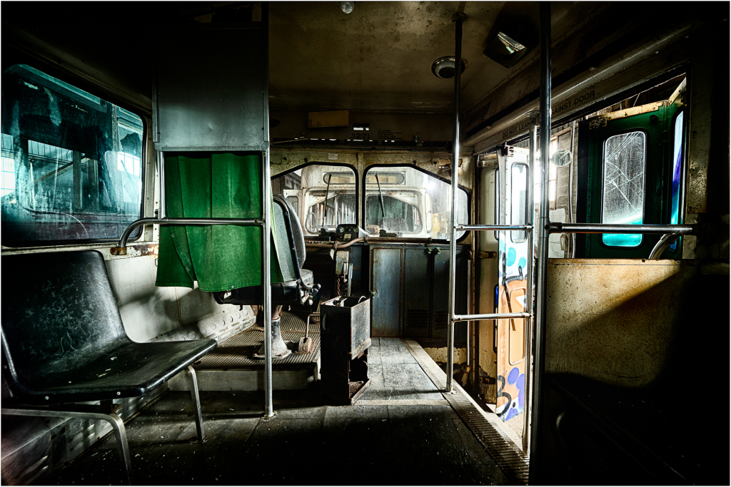 Interior of an abandoned trolley, shadows loom in the eldritch gloom.