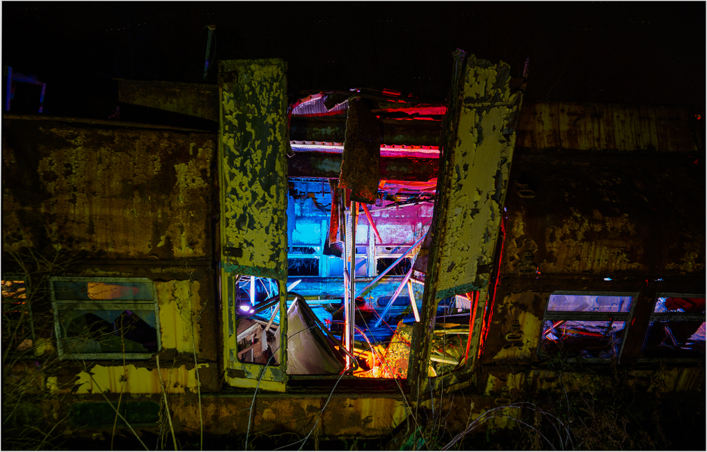 A rusted trolley with peeling paint, illuminated by eerie lights.