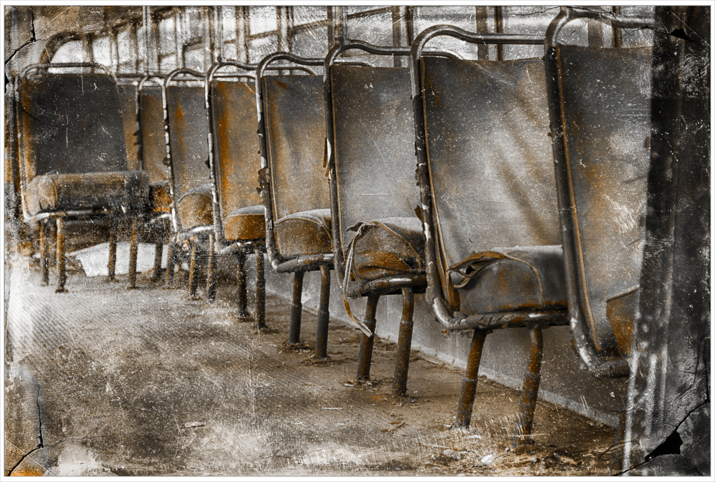 Abandoned trolley seats in a desolate graveyard of rust and decay.