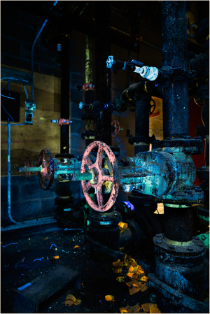 Colorful pipes and valves glowing under UV light, a quirky industrial scene.